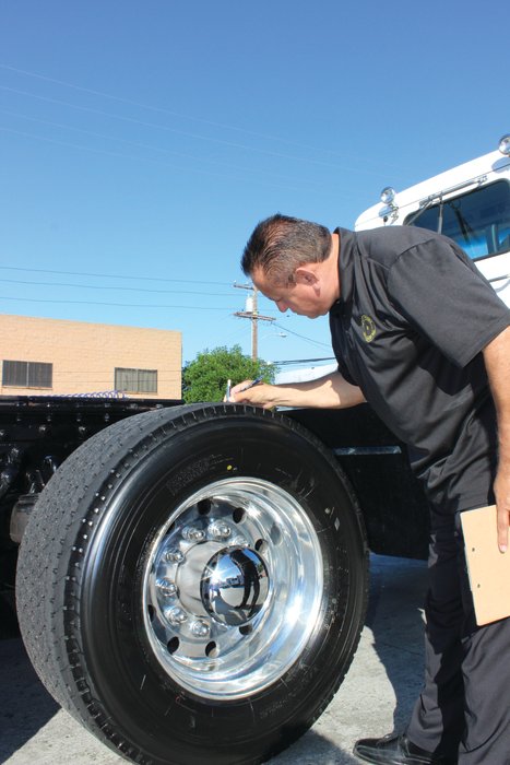 Joe Godina, fleet manager, Heavy Weight Transport, inspects the tread on a Yokohama TY517 UWB tire